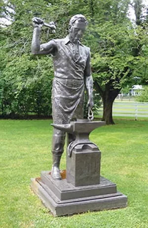 A statue of John Deere sits near the entrance to the John Deere Historic Site in Grand Detour, Illinois. Deere honed the self-scouring steel plow at his blacksmith shop, a working replica of which can be seen on the site’s grounds. - PHOTOS BY BRENT BOHLEN