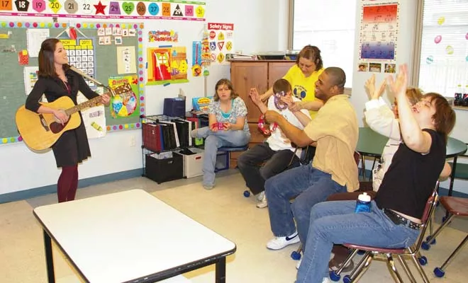 In 2011, students of The Hope Institute for Children and Families enjoy guitar playing and songs with former music therapist Rachel Rambach. - PHOTO BY DAVID HINE