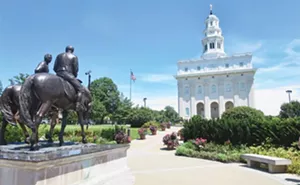 The exterior of the Nauvoo Temple is a replica of the original temple that was burned and destroyed. Nearby is a sculpture depicting Joseph and Hyrum Smith’s last ride to Carthage. - PHOTOS BY JOHN CAMPER