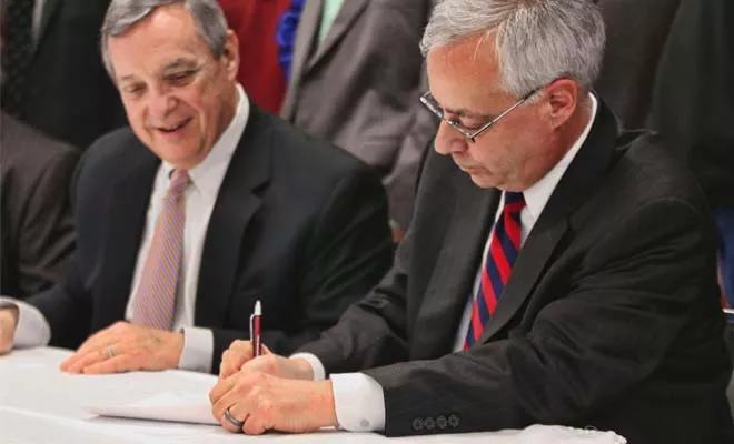 With U.S. Sen. Dick Durbin of Illinois looking on, Ken Humphreys, CEO of the FutureGen Alliance, signs a labor agreement on Monday to provide union labor for the FutureGen project planned in a rural area outside Jacksonville. The agreement may signal that - PHOTO BY PATRICK YEAGLE