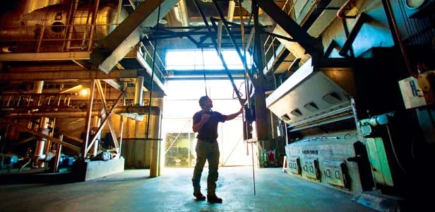 Bill Viele, a stationary fireman, loads coal into a hopper that feeds the No. 3 boiler inside the Capitol power plant. - PHOTO BY JONATHAN KIRSHNER