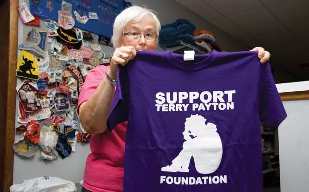 Teri Dennis, owner of Teri's Threads in Paris, holds a T-shirt sold at her shop to raise money for Terry Payton's defense fund. - PHOTO BY PATRICK YEAGLE