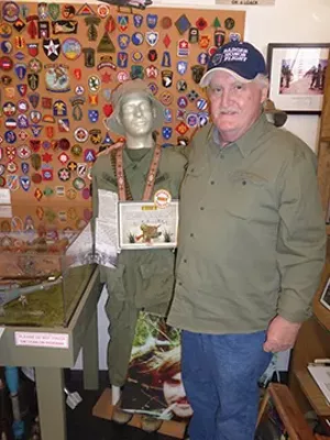 David Estes shows the fatigues he wore in Vietnam on one of 250 mannequins displaying military uniforms at the Livingston County War Museum in Pontiac. David’s father, Dal, began the museum with his own collection of military memorabilia in 2004, a - MARY BOHLEN