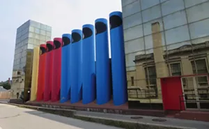 The giant colorful “crayons” or “organ pipes” of the AT&T/SBC Switching Center compliment the mirrored glass façade of the building designed by Paul Kennon of Caudill, Rowlett, Scott in 1978. - PHOTO BY JOHN CAMPER.