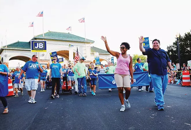 Pritzker waving to th​e crowd with running mate Rep. Julianna Stratton, D-Chicago, at the Illinois State Fair Twilight Parade in August.