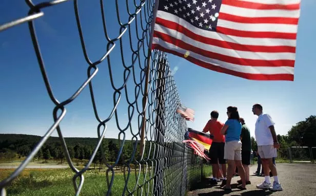 Visitors peer past the fence to the Flight 93 National Memorial, at the Flight 93 crash site and the newly completed memorial in Shanksville, Pa. - HOTO BY LAURENCE KESTERSON/MCT