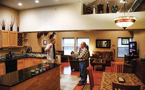 Chris Nickell of Springfield, left, shows visitors around the apartment that he and his wife renovated in the building at 118 S. 4th St. The Nickells bought the building last year and plan to finish renovating more units in the coming months. - PHOTO BY PATRICK YEAGLE