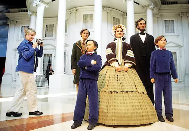 The president and his family greet visitors in the museum’s entry plaza, with a replica of the White House in the background. - PHOTO BY E. JASON WAMBSGANS