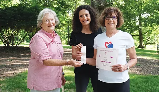 George Anne Daly, left, and Debbie Huffman, center, were codirectors of the first Women’s Distance Festival. They’re with Karen Witter, displaying her finisher’s ribbon and certificate from the July 1980 race, signed by Daly and Huffm - PHOTO BY LEE MILNER