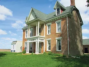 The Marbold house in 1990, and today. The restoration work so far has focused on structural and exterior repairs. - PHOTO COURTESY HMFA