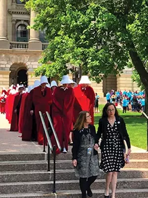Sen. Melinda Bush, D-Grayslake, and Rep. Kelly Cassidy, D-Chicago, arrived at a rally outside the Statehouse trailed by about 60 women dressed as Handmaids, characters from Margaret Atwood’s dystopian novel. - PHOTO COURTESY OF PLANNED PARENTHOOD OF ILLINOIS