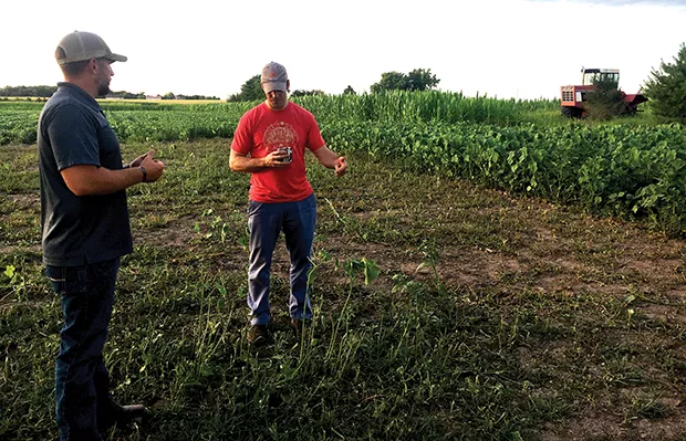 Farmer Caynan Sherwood (left) and an Illinois Stewardship Alliance member discuss conservation practices and policy during an on-farm potluck at 2 Mile Creek Organic Farm, one of the Alliance's many events.