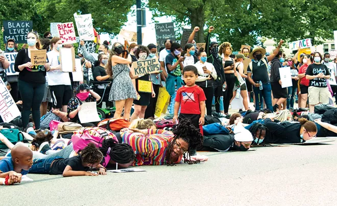 At the June 1 protest at the Capitol, Tiara Standage, center front, and three of her children lie on the pavement in solidarity with George Floyd, while her little boy looks on. - PHOTO BY BRANDON TURLEY