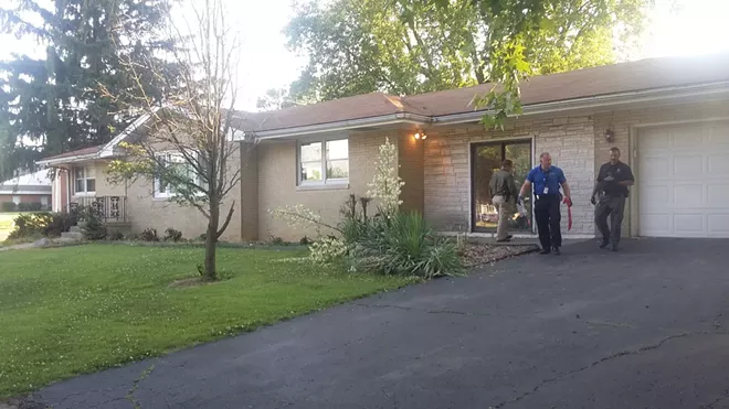 Police search a home recently acquired by Collins, not far from his Laketown house. - PHOTO BY BRUCE RUSHTON