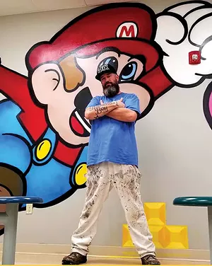 Ron stands with his completed Super Mario mural located in the cafeteria of the Lincoln Prairie Behavioral Health Center in Springfield. Spray-painted November 2019.