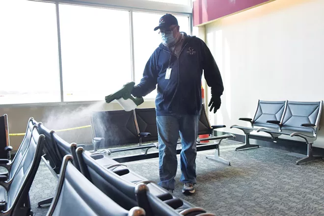 Springfield Airport Authority custodian Jim Coleman uses an electrostatic spraying machine to disinfect the waiting area at Abraham Lincoln Capital Airport. - PHOTO BY DAVID BLANCHETTE