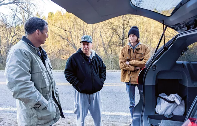 Hindi, center, discusses strategy with Greg Campbell, left, and Chad Campbell, right, near a suspected North Carolina cockfight that didn't happen. - PHOTO BY BRUCE RUSHTON