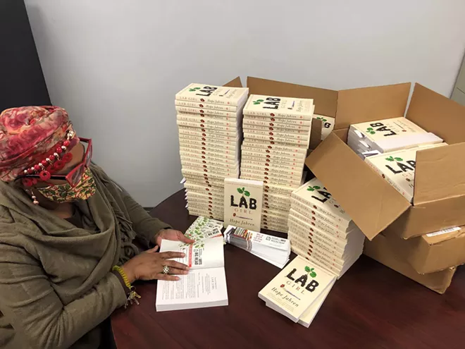 LLCC Community Education program assistant and Academy of Lifelong Learning member Jennifer Lewis. She is prepping the books to add a Big Read label inside the cover and stuffing them with an NEA Big Read bookmark. - PHOTO COURTESY OF LINCOLN LAND COMMUNITY COLLEGE.