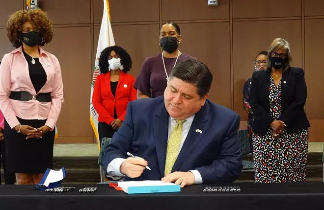 Gov. JB Pritzker, accompanied by members of the Illinois Legislative Black Caucus and the health care community April 27 at Memorial Medical Center in Springfield, signs a health care reform bill backed by the Black Caucus. Capitol News Illinois - PHOTO BY PETER HANCOCK