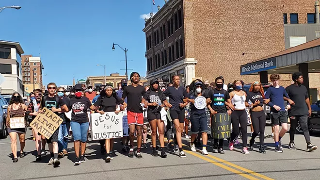 Smylie stands center, to the right of a young man in red shorts. She wears a shirt that says, "I can't breathe" during a march against police brutality in June of last year. - CREDIT: RACHEL OTWELL