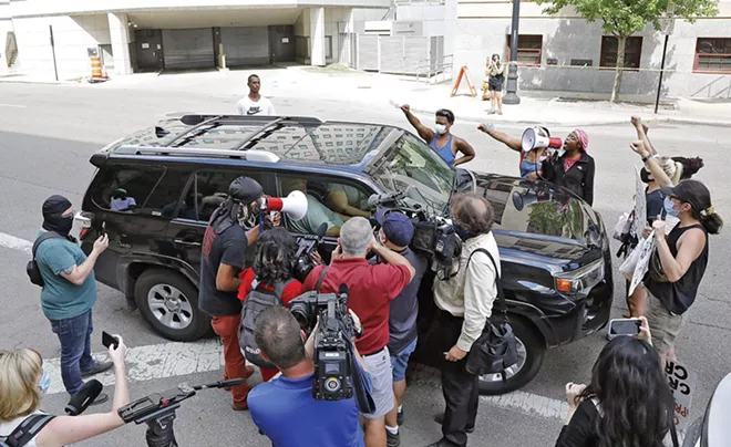 Protesters and reporters outside a federal courthouse in Ohio surround a vehicle occupied by John Householder, former speaker of the Ohio House of Representatives, who's been charged in an alleged $60 million bribery scheme to subsidize nuclear plants. Although no longer speaker, Householder was reelected last year and remains a lawmaker. - CREDIT: KYLE ROBERTSON/DISPATCH.