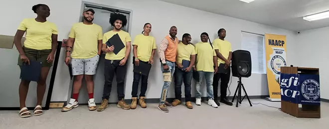 Calvin Pitts, center in orange, stands with recent graduates of his construction training program during a ceremony at the NAACP headquarters in Springfield. - CREDIT: RACHEL OTWELL