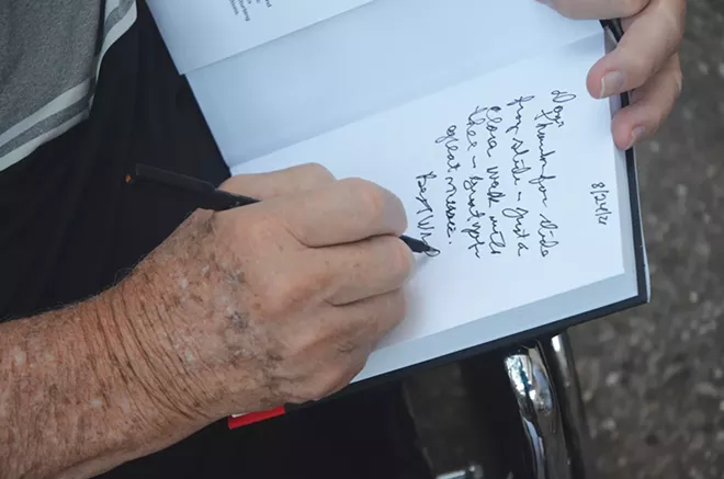 George Ryan signs a copy of his book, Until I Could Be Sure. - PHOTO BY DAVID BLANCHETTE