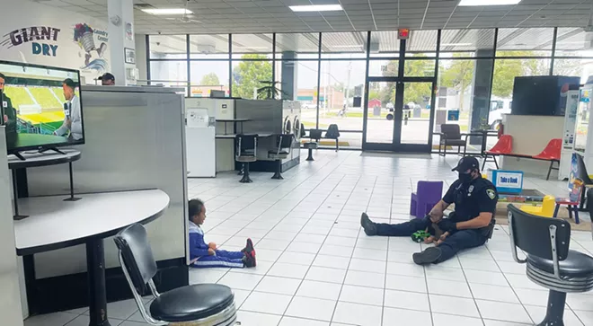 Springfield police officer Tyler Woolsey responded to a disturbance call at All In One Laundry Center & Services but took time to play with the children there. - PHOTO COURTESY OF PAMELA FRAZIER