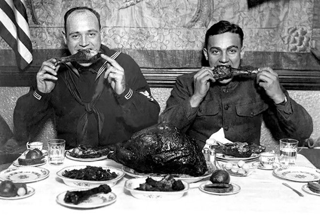 Two American servicemen enjoy a public Thanksgiving dinner in New York City, 1918. Tens of thousands of wayward troops joined public dinners like this.