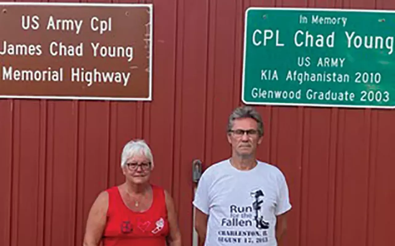 Brett and Jerry Hopkins of Rochester with signs honoring their son, Chad