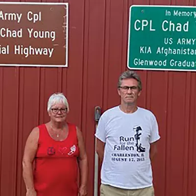 Brett and Jerry Hopkins of Rochester with signs honoring their son, Chad