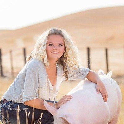 Carrie Hennigar, a senior at Colton High School, is doing her senior project to help others. She is feeding out a pig on home-grown feed from the Phil Druffel Farms and donating the meat to the Pullman Food Bank. The pig will be butchered on Feb. 24 at the University of Idaho Meats. Many families will benefit from her generosity. This photo was taken at her family home on Johnson Road between Johnson and Colton. Carrie is 18 years old and the photograph was taken by Almoto Rose Photography.