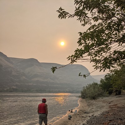 1.  July 15, 2021

2.  Asotin, Washington at the boat ramp

3.  Judy Broumley

4.  My husband, Roy Broumley, walking along the river in smoke filled skies.  The sun is reflecting on the water in an orange haze.