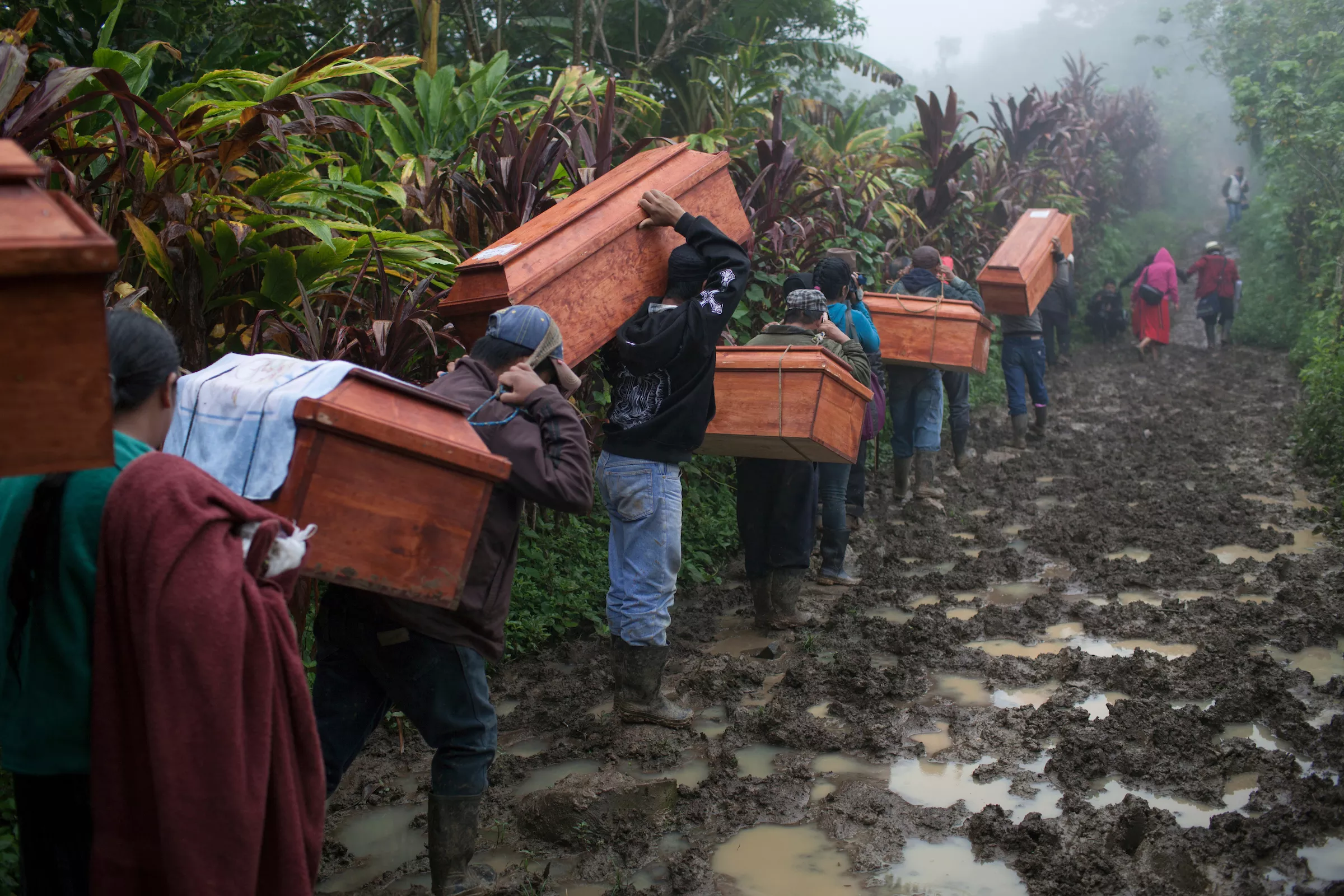 Community members from Estrella Polar and Covadonga hamlets head to the cemetery to bury the human remains of 77 war victims exhumed from mass graves in 2009. The victims were killed during the Covadonga massacre by the Guatemalan military forces on March 29, 1982, during the de facto government of General Efrain Rios Montt as part of a scorched earth campaign against numerous Mayan villages believed to support the guerrilla forces. Estrella Polar, Chajul, Quiché, Guatemala. November 20, 2014. - JAMES RODRIGUEZ / MIMUNDO.ORG
