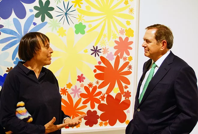 Standing in front of one of her brightly colored prints, artist Polly Apfelbaum talks with donor Jordan Schnitzer during the opening reception of an exhibit of her work in the museum of art bearing Mr. Schnitzer's name at Washington State University September 4. , - KAI EISELEIN