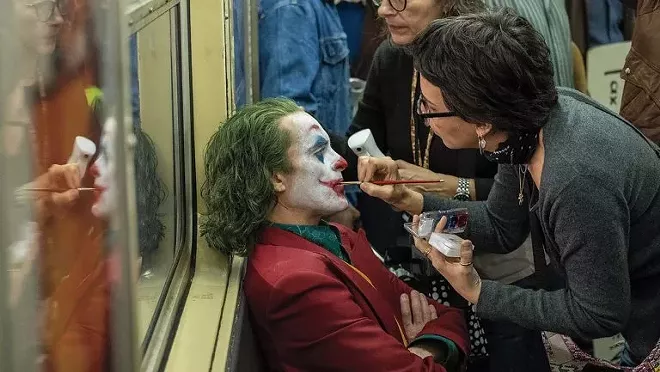 Actor Joaquin Phoenix has makeup applied to his face on the set of “Joker.” On film sets, maintaining a 6-foot distance is not likely to happen as actors and crew members need to get close to each other. Photo credit: Warner Bros.