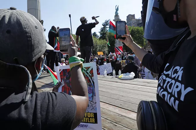 Two women use their cell phones to record a speaker during a Caribbean-led Black Lives Matter rally at Brooklyn's Grand Army Plaza, Sunday, June 14, 2020, in New York. A video of George Floyd's death went viral following the incident, capturing the world's attention. - AP PHOTO/KATHY WILLENS
