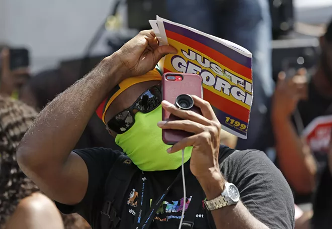 A person uses his cell phone to record during a Caribbean-led Black Lives Matter rally at Brooklyn's Grand Army Plaza, Sunday, June 14, 2020, in New York. - AP PHOTO/KATHY WILLENS