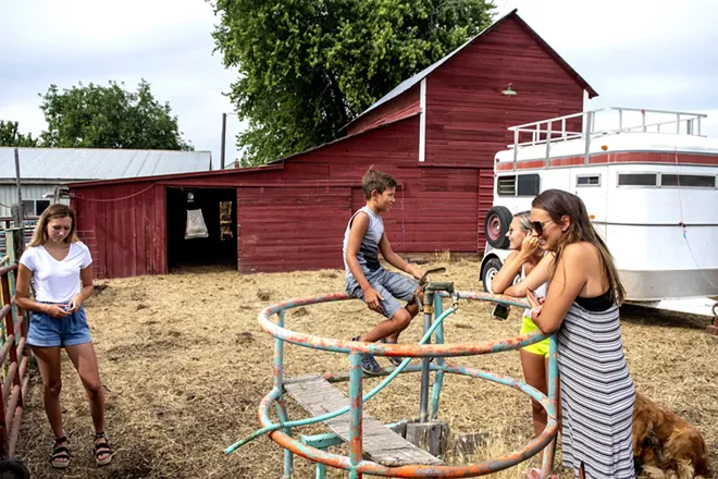 Jarrett Barnes, 8, talks to his older sister Jaylen Barnes, 19, as their mother Julie stands by and other sister Kadence Barnes, 15, exits the enclosure of Big Red, a steer she is raising for 4-H as the family sits outside the barn on their property. The barn is over 100 years old, having been built before the town of Lewiston was created. August Frank/Tribune - AUGUST FRANK/TRIBUNE