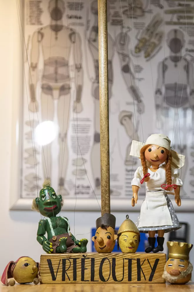 A mixture of marionette heads, made by Holbert’s grandfather, Vladimir Vrtelova, and reconstructed bodies by Holbert sit in front of a poster instructing how to make marionette body parts. - ZACH WILKINSON / INLAND 360