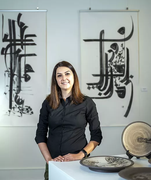 Tirazheh Eslami — an artist, faculty art professor at Lewis-Clark State College and exhibit coordinator — poses for a portrait in behind Persian pottery on display at the Lewis-Clark State College Center for Arts & History in downtown Lewiston. Eslami’s show “Persepolis: Introducing Persian Culture to the West” will open on Sept. 24. - PETE CASTER/360