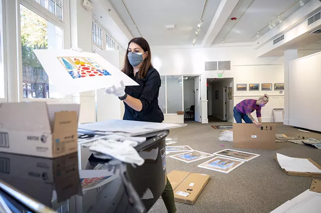 Exhibit coordinator Tirazheh Eslami takes out a piece of art sent from Iran as she prepares to frame it with the help of intern Josephine Wimer (right) as they prepare for the opening of “Persepolis: Introducing Persian Culture to the West” on Thursday at the Lewis-Clark State College Center for Arts & History in downtown Lewiston. - PETE CASTER/360