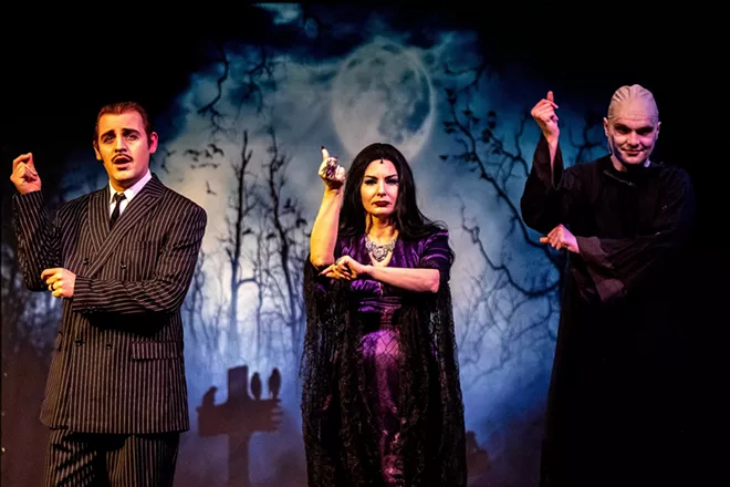 Micheal Keene, playing Gomez Addams, Amy Stout, playing Morticia Addams, and Aven Sparkman, playing Uncle Fester, snap their fingers during the opening song for the Addams Family at the old Lewiston High School on Monday evening. - AUGUST FRANK/360