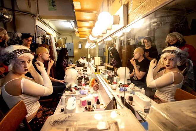 Elliss Dilling (left), playing a flapper ancestor, Aven Sparkman, playing Uncle Fester, and Amy Stout, playing Morticia Addams, prepare their makeup and costumes before a rehearsal for the Addams Family at the old Lewiston High School on Monday evening. - AUGUST FRANK/360