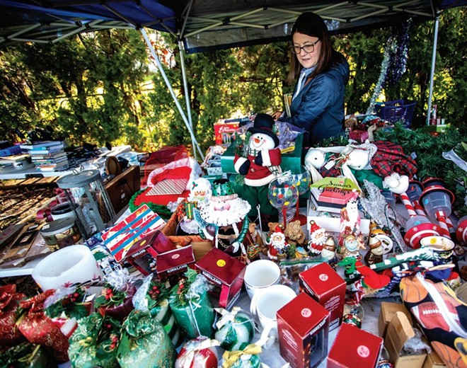 Sarah Baney looks over tables strewn with Christmas products at a recent garage sale in Lewiston - AUGUST FRANK/INLAND 360