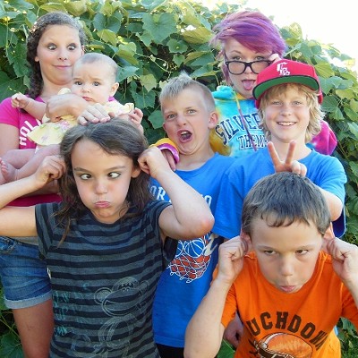 Describe your imagCousins gathered for a picture at thier Grandma Val's house. Olivia, Chloe,Dylan, Morgan, Maggie, Lilly and Ian enjoy making the "crazy faces" at the 4th of July family BBQ.
    e