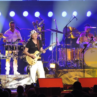 Several time Grammy Award winner Carlos Santana (in white pants, black shirt and with the guitar) plays for the audience in a March 4, 2018 performance in Spokane, WA. Photo taken by Keith Gunther