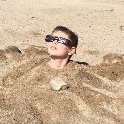 Eliot Miura, 8, the son of Mike and Tanya Miura of Moscow and grrandson of Jim and Fauna Allen of Moscow, watches the eclipse on the beach at Cascade Lake. &nbsp;Photo by Tanya Miura.