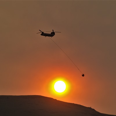 A Chinook fly's in front of the filtered sun from all the smoke just south of Buffalo Eddy on July 9, 2021. There was at least four helicopters that was dropping water on the Idaho side.