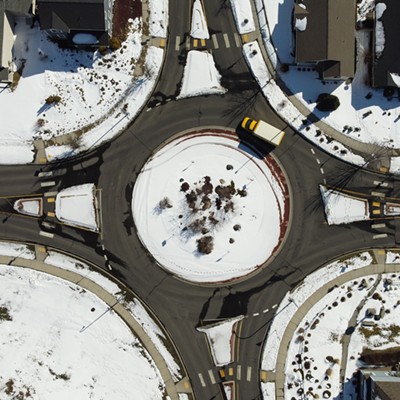 Yellow truck goes around traffic circle in Moscow where Joseph Street, White Avenue, Robinson Park Road, and notting Hill Drive intersect.